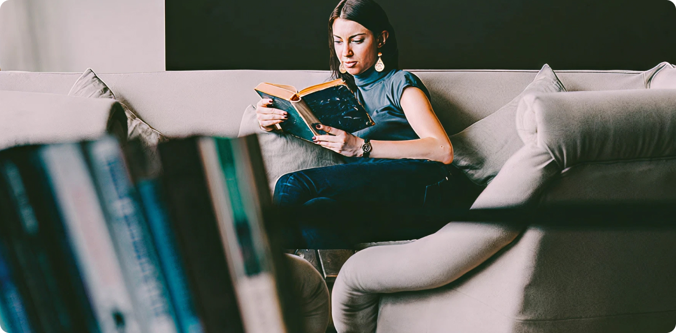 외국 여성이 쇼파에 앉아 책읽는 모습